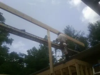 Carpenter setting a ridge beam over a new addition frame — Ice Dam Removal by Roofing Brothers in Clallam Bay